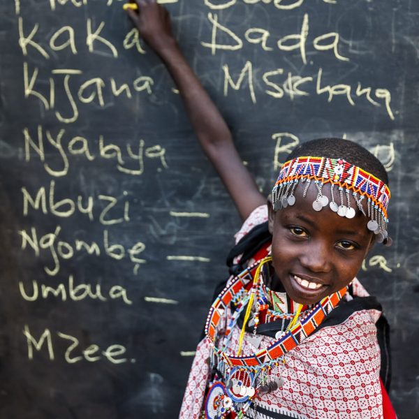 Little African girl during Swahili language class, East Africa African children from Maasai tribe during Swahili language class in remote village, Kenya, East Africa. Maasai tribe inhabiting southern Kenya and northern Tanzania, and they are related to the Samburu.